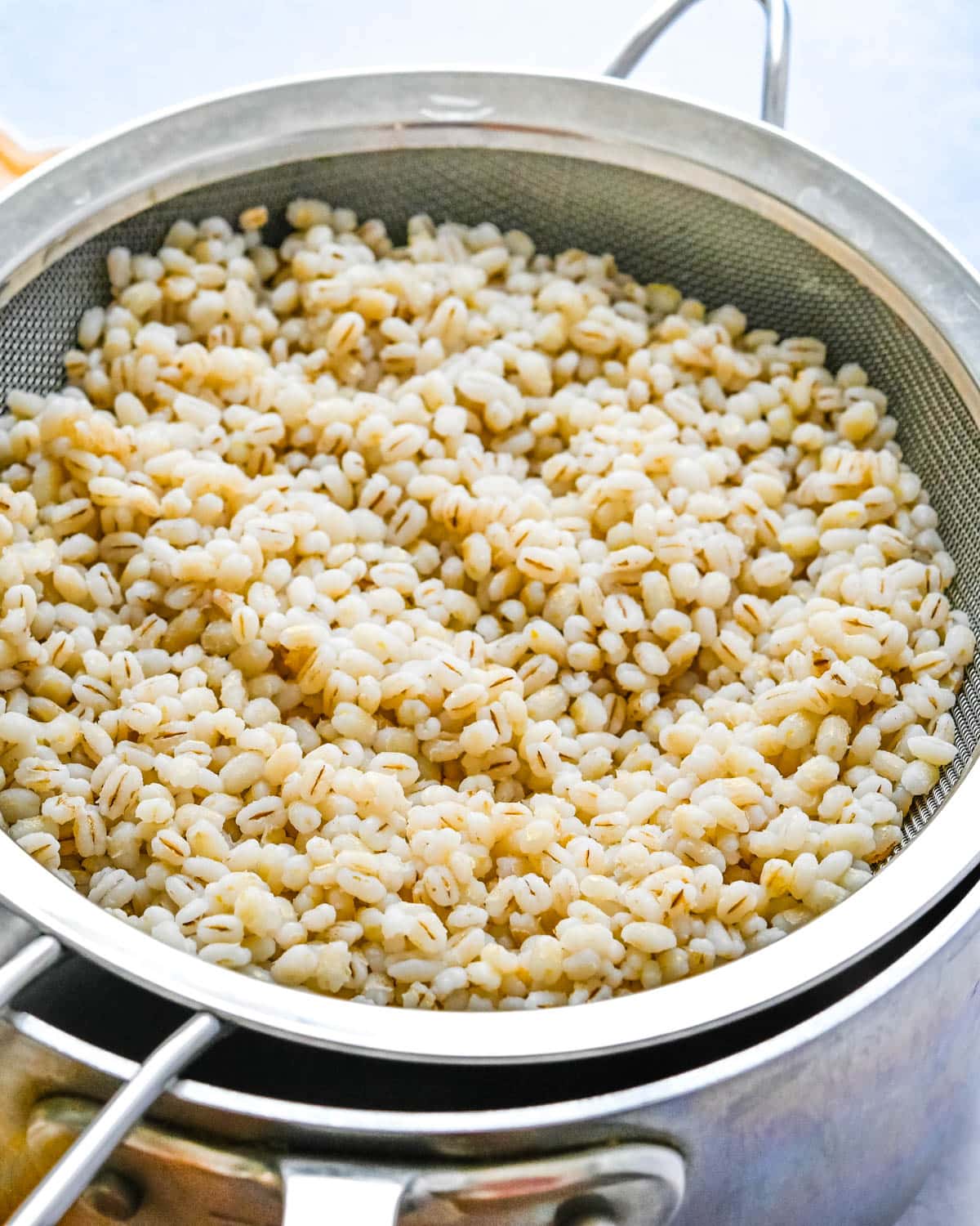Cooked barley in a strainer.