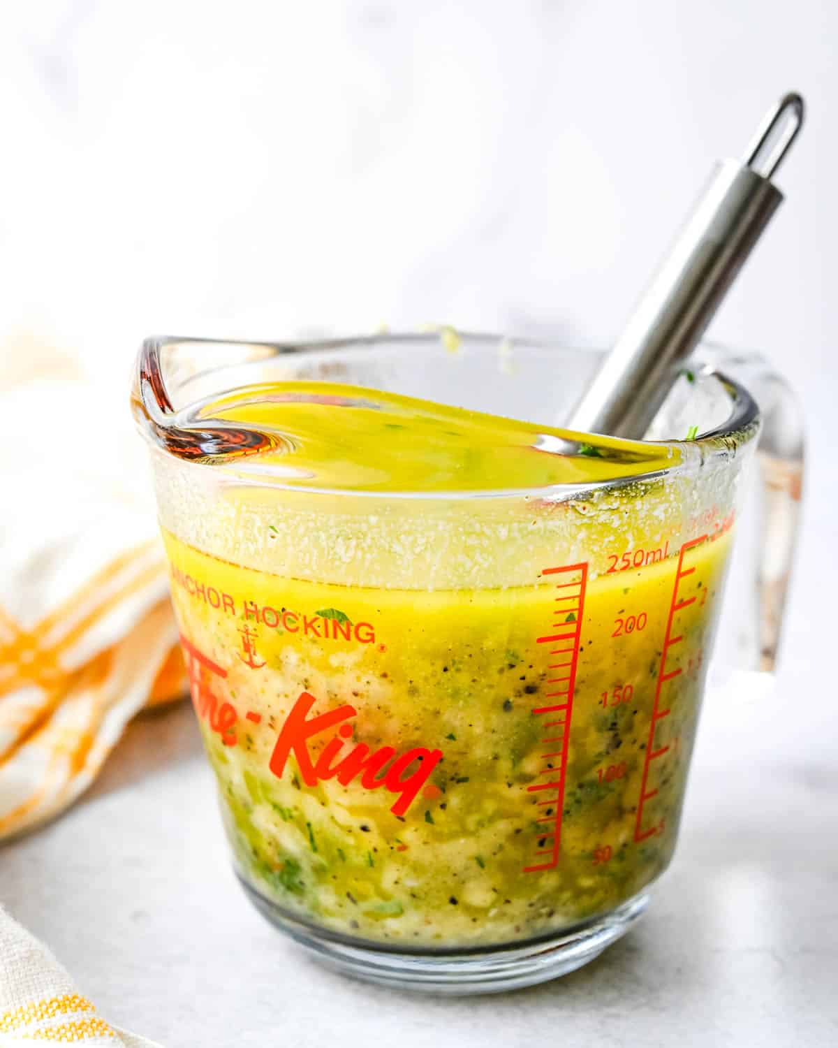 Whisking the vinaigrette in a measuring cup.
