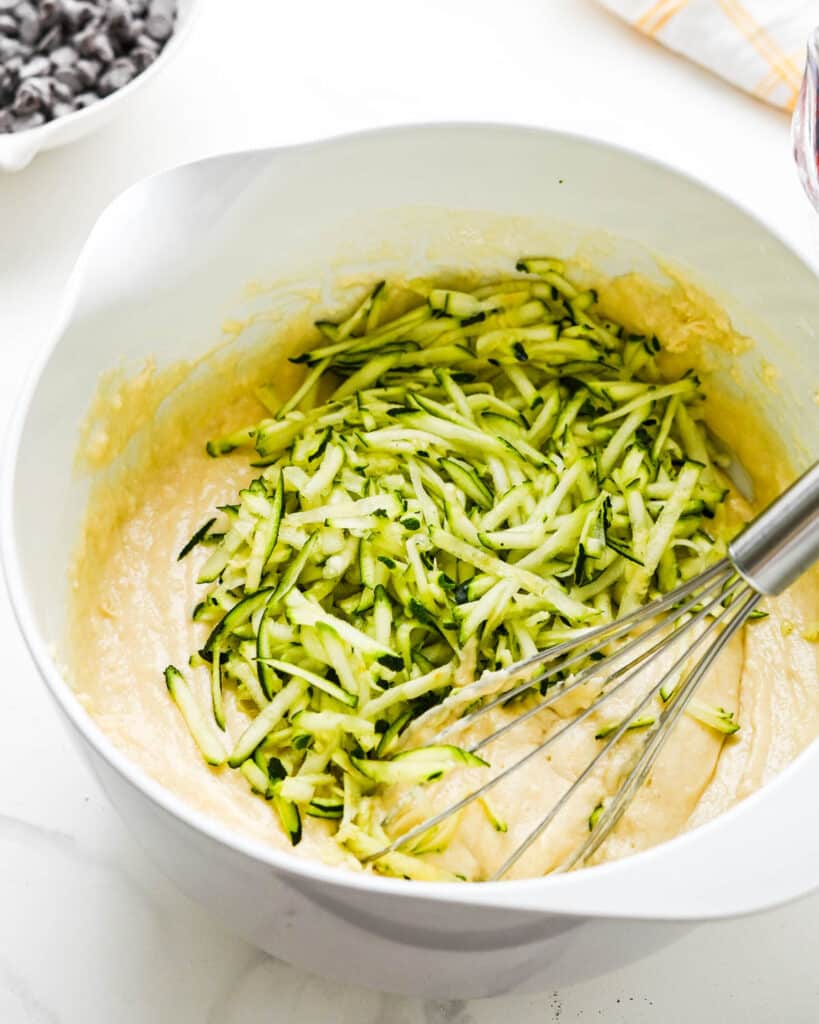 Adding the shredded zucchini to the batter.