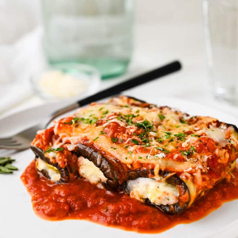 Eggplant rollatini on a white plate with a fork.