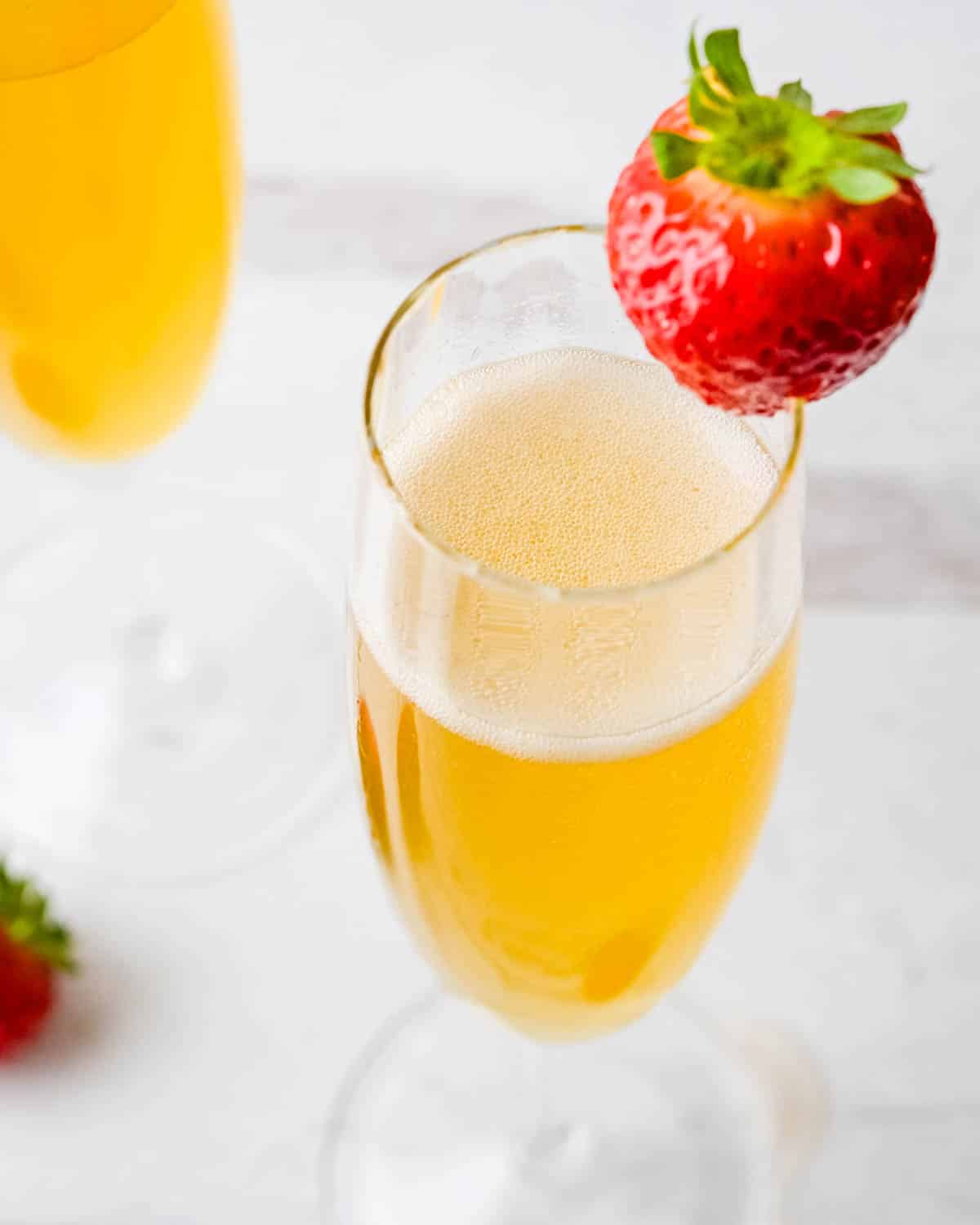 An elderflower and sparkling prosecco cocktail garnished with a strawberry.
