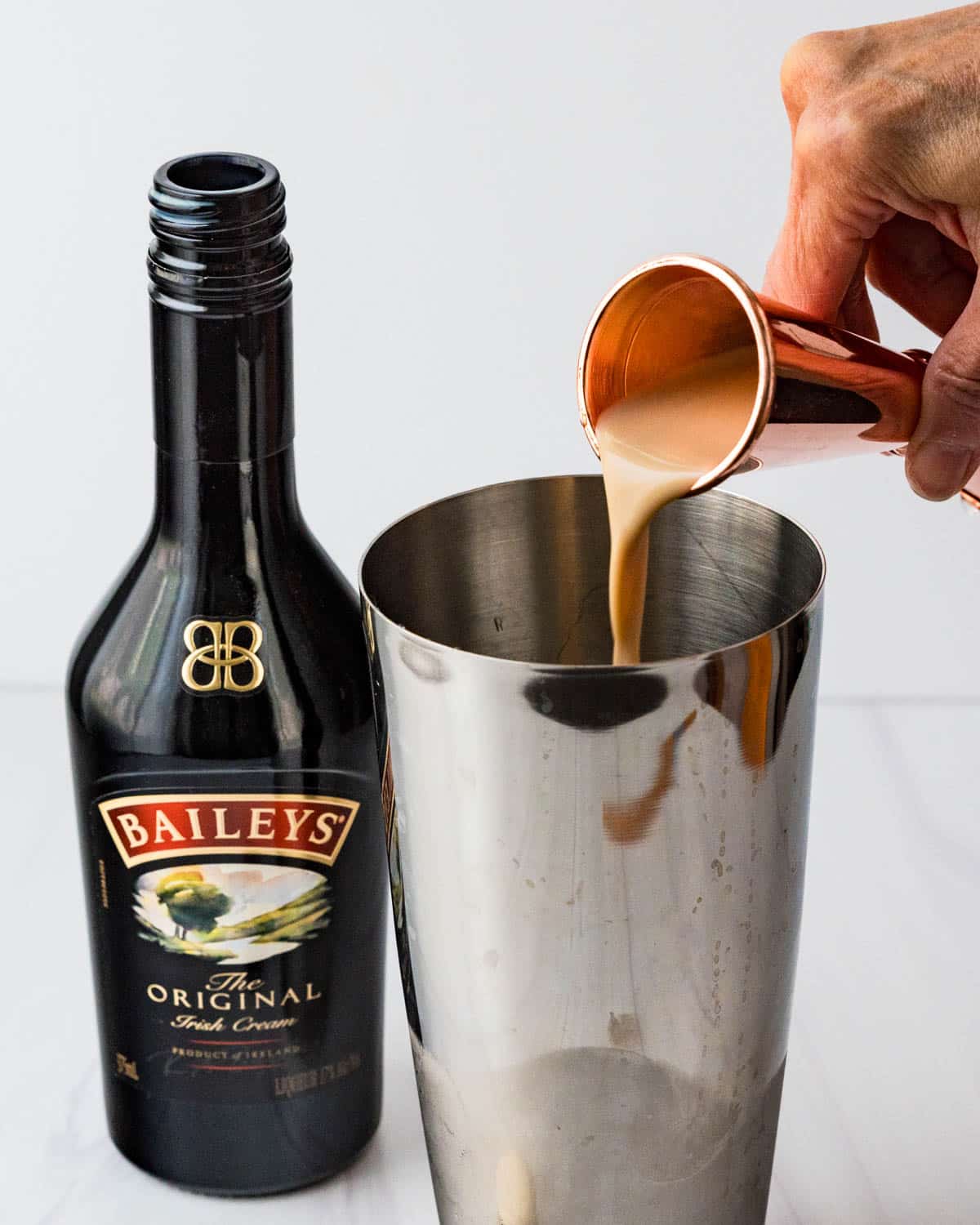 Adding Baileys Irish Cream to teh shaker.