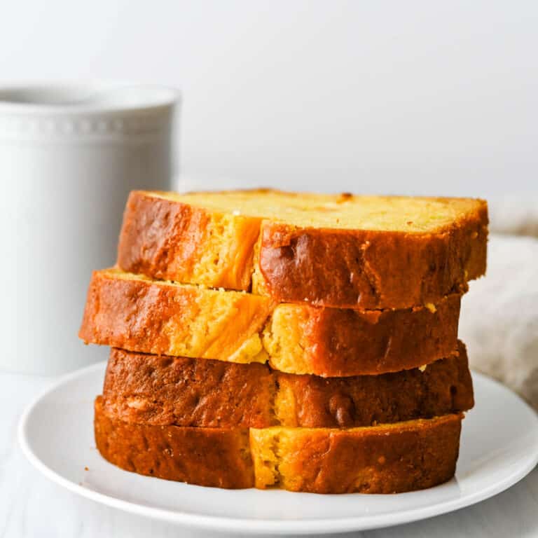 A stack of four slices of mango bread on a plate.