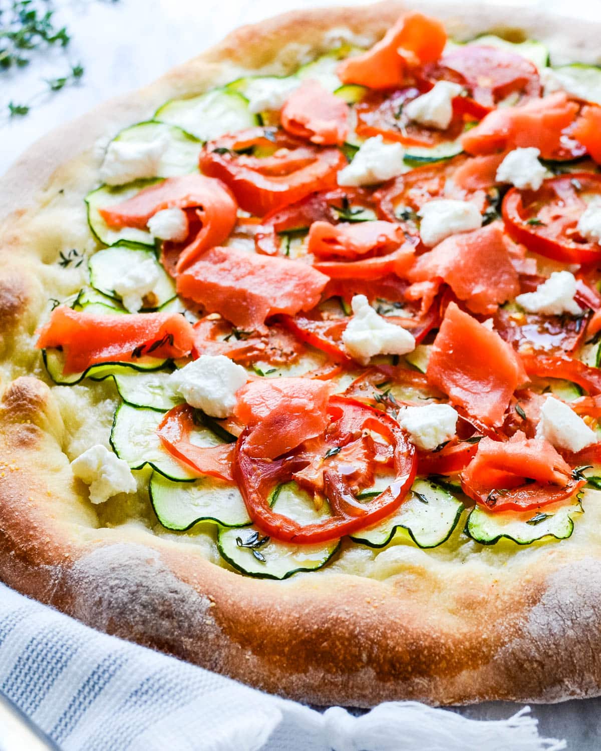 Salmon pizza with crumbles of goat cheese.
