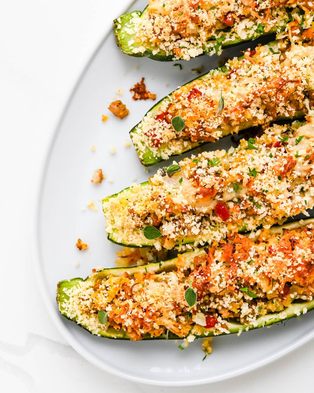 A platter of zucchini boats with Italian sausage and panko breadcrumbs.