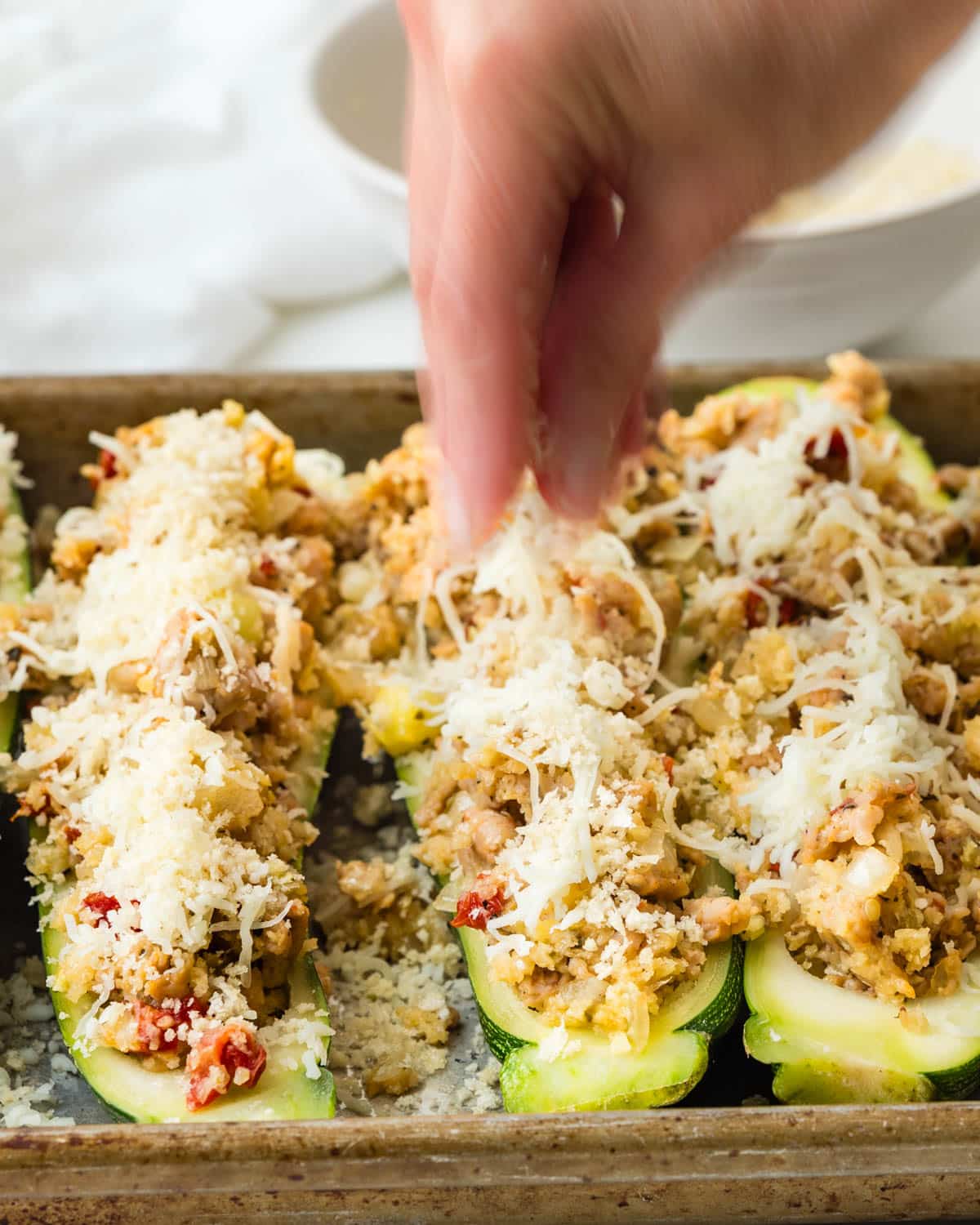 Topping zucchini boats with panko breadcrumbs. 