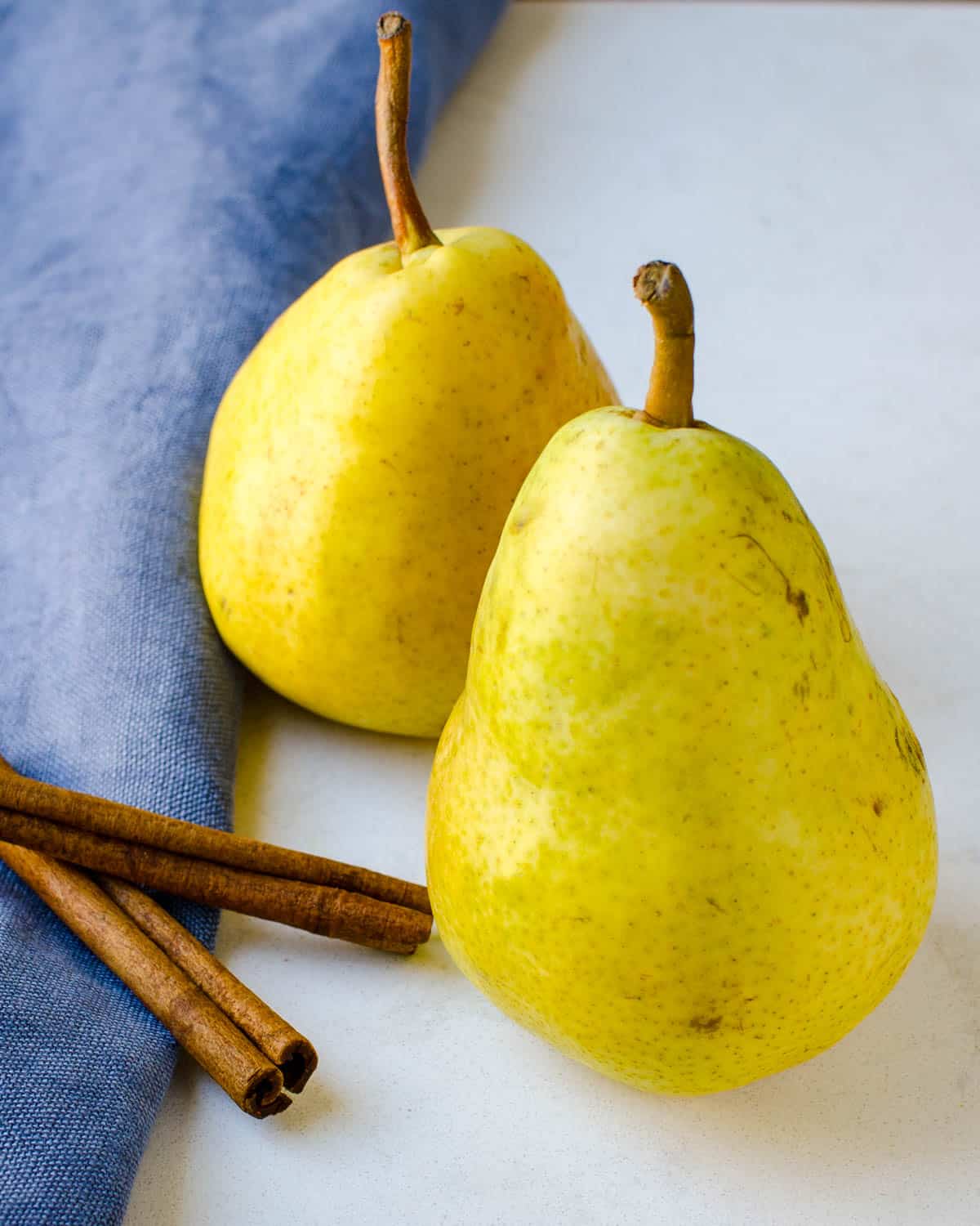 Two pears and sticks of cinnamon.