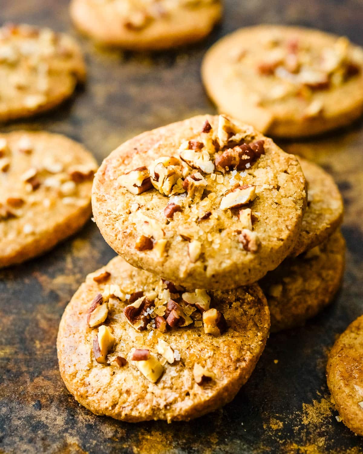 A stack of pecan cookies on a sheet pan.