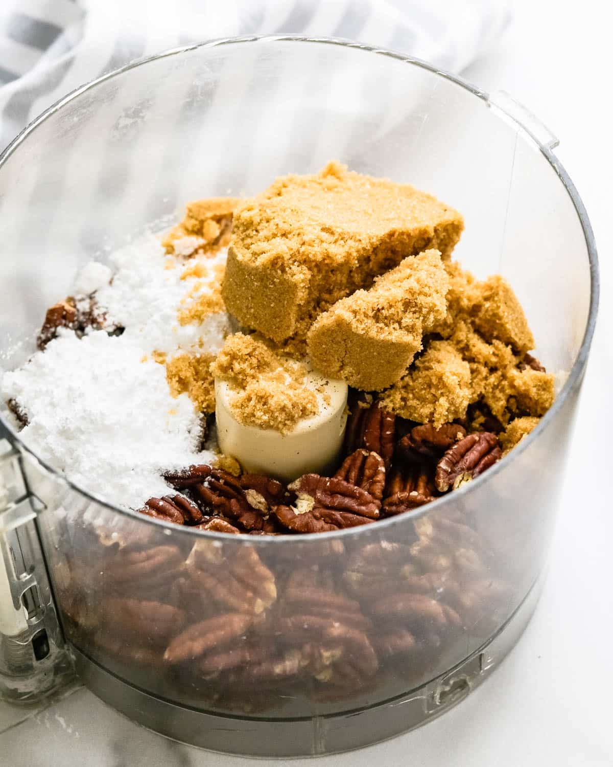 Blend brown sugar and powdered sugar with toasted pecans in a food processor.