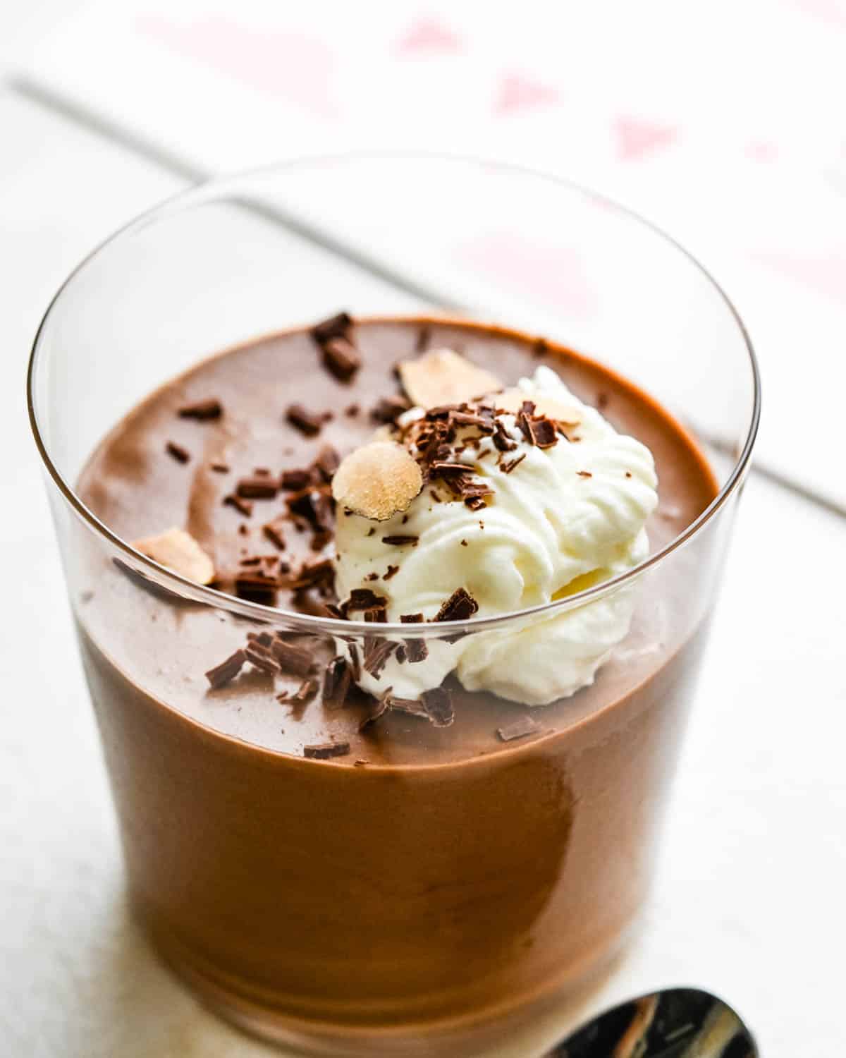 a chocolate mousse with whipped cream and chocolate shavings. 