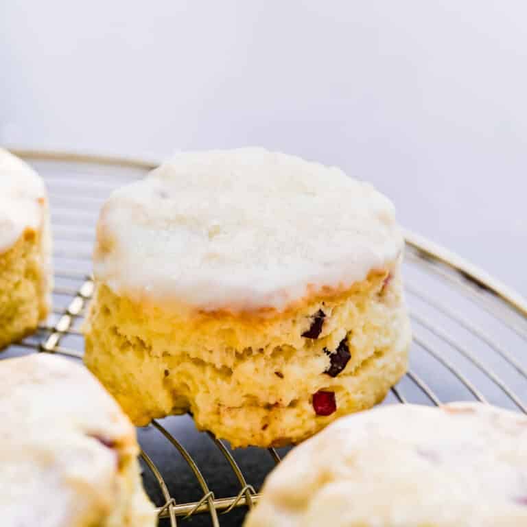 Cranberry lemon scones with glaze drying on a rack.
