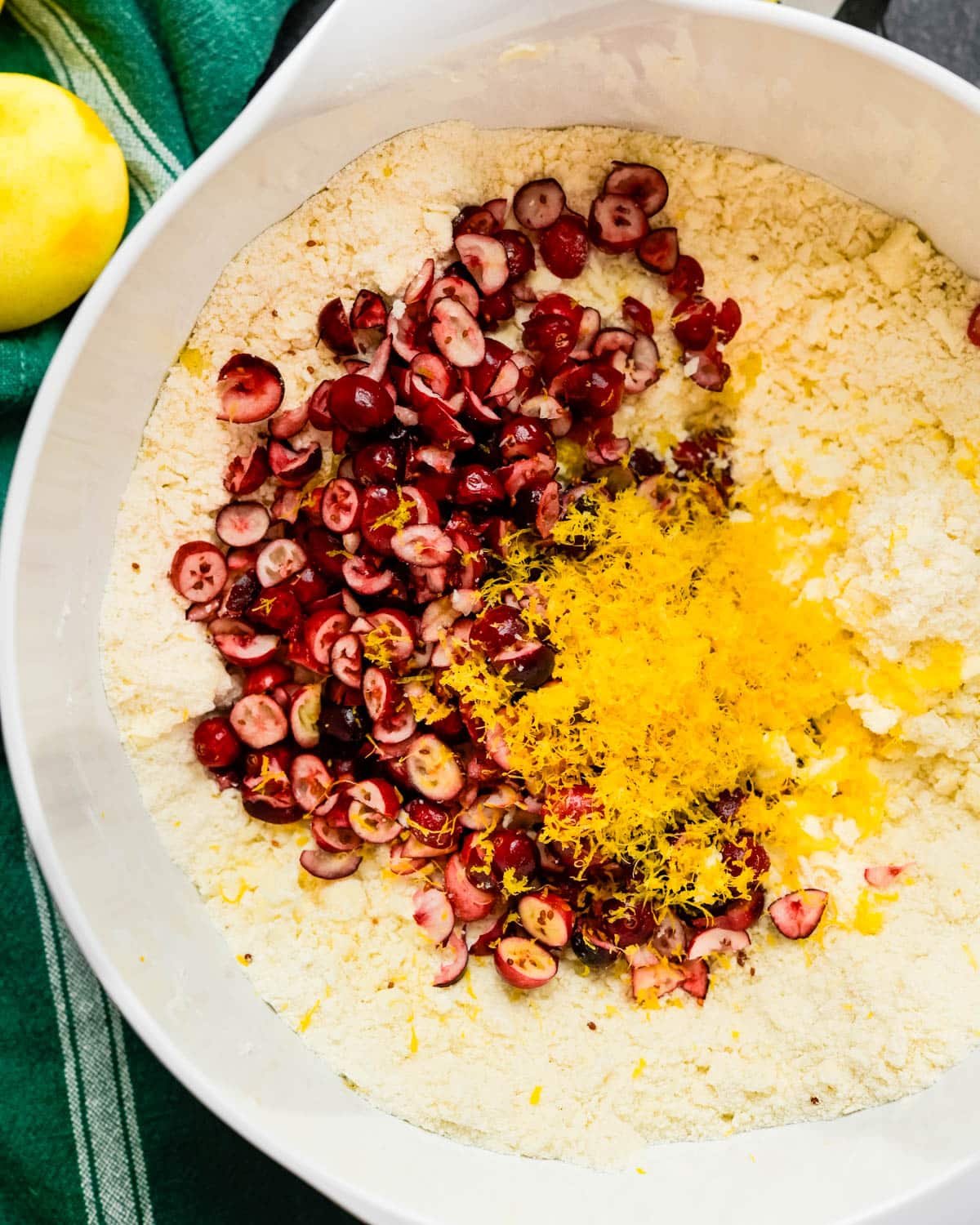 Adding chopped cranberries and lemon zest to the dry ingredients.