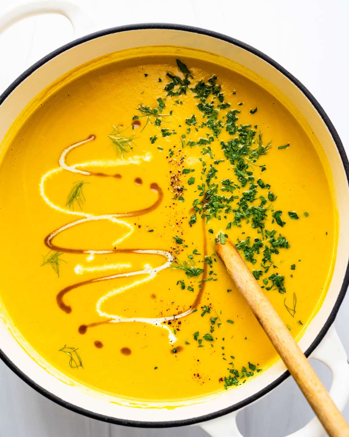 a pot of creamy pumpkin soup with maple and cream.