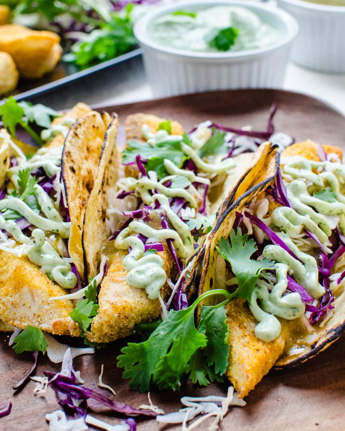 A plate of fish tacos with crema.