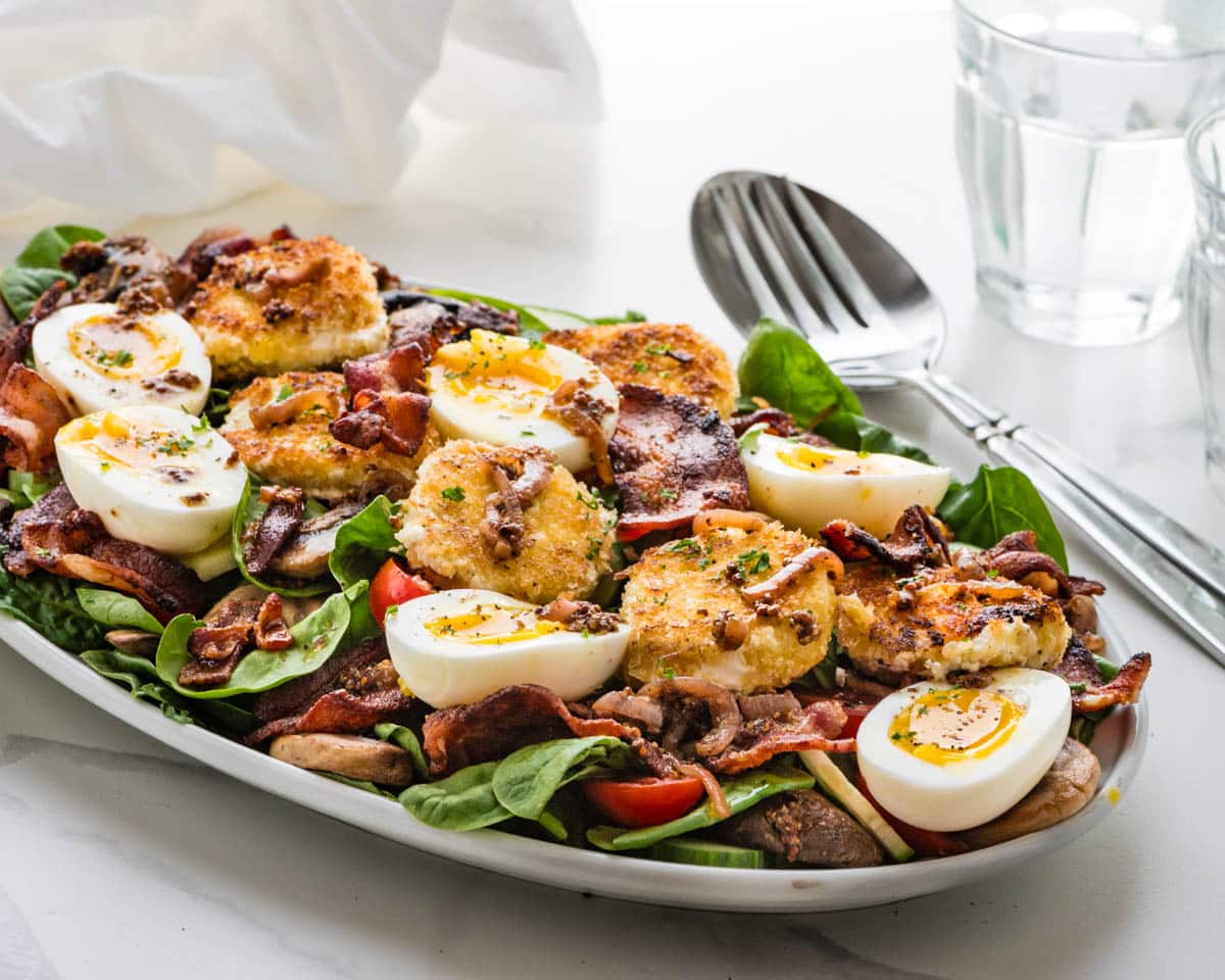 A platter of the spinach salad with fried goat cheese and bacon dressing.