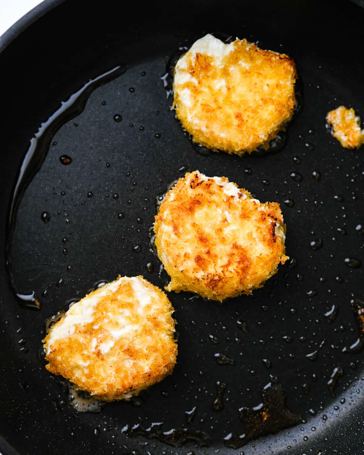 Frying goat cheese in a nonstick skillet until gold