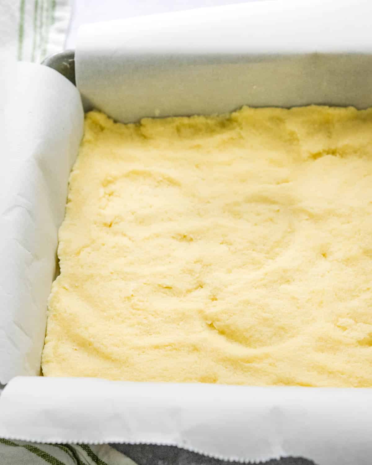 Pressing the prepared crust into the tin.