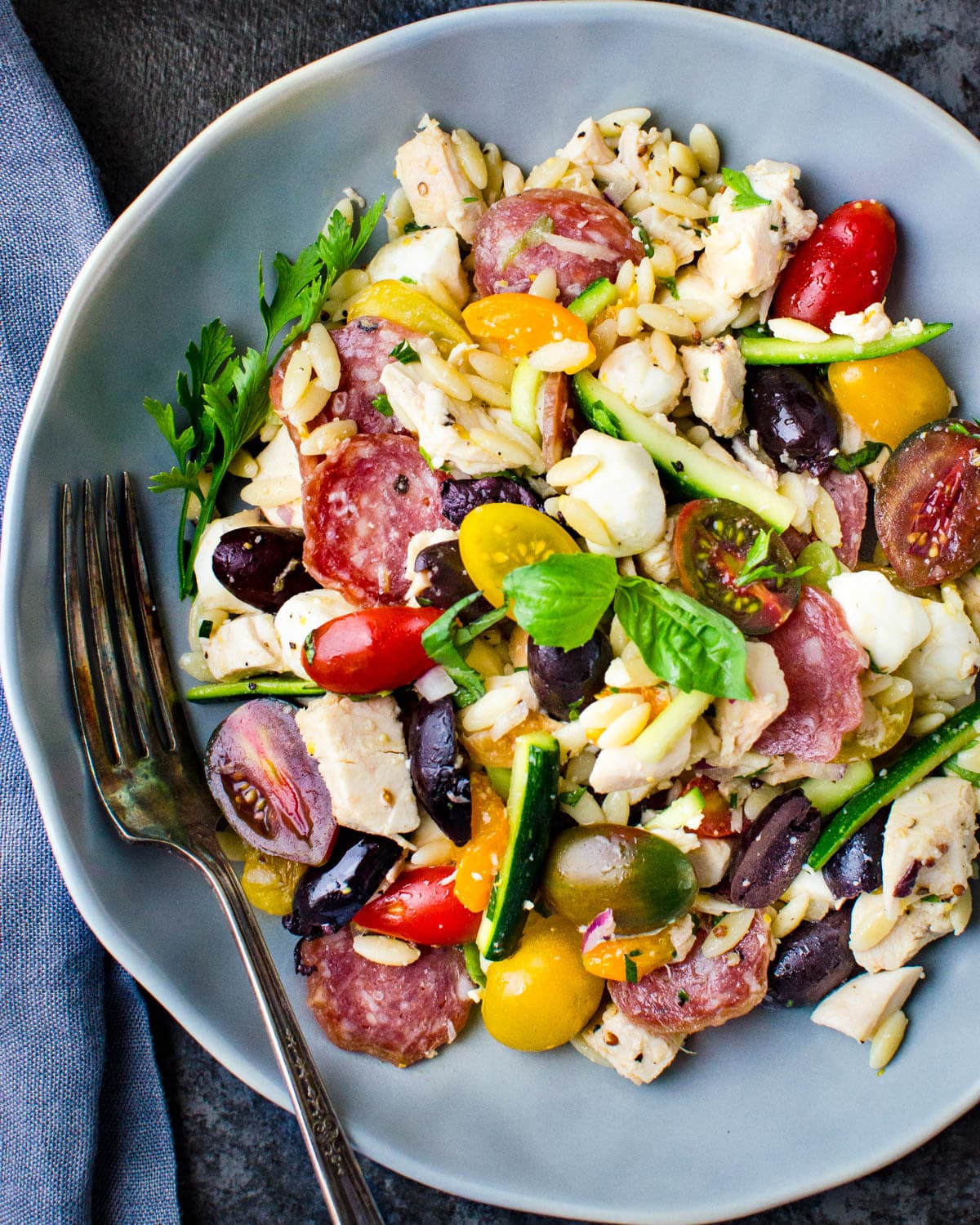 Serving the Mediterranean orzo salad on a plate.