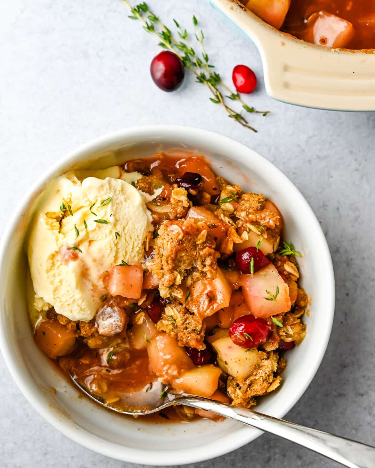 Adding a scoop of ice cream to the pear cranberry crisp.