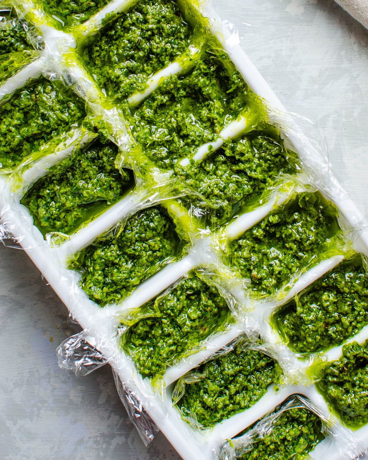 freezing basil pesto in an in an ice cube tray.