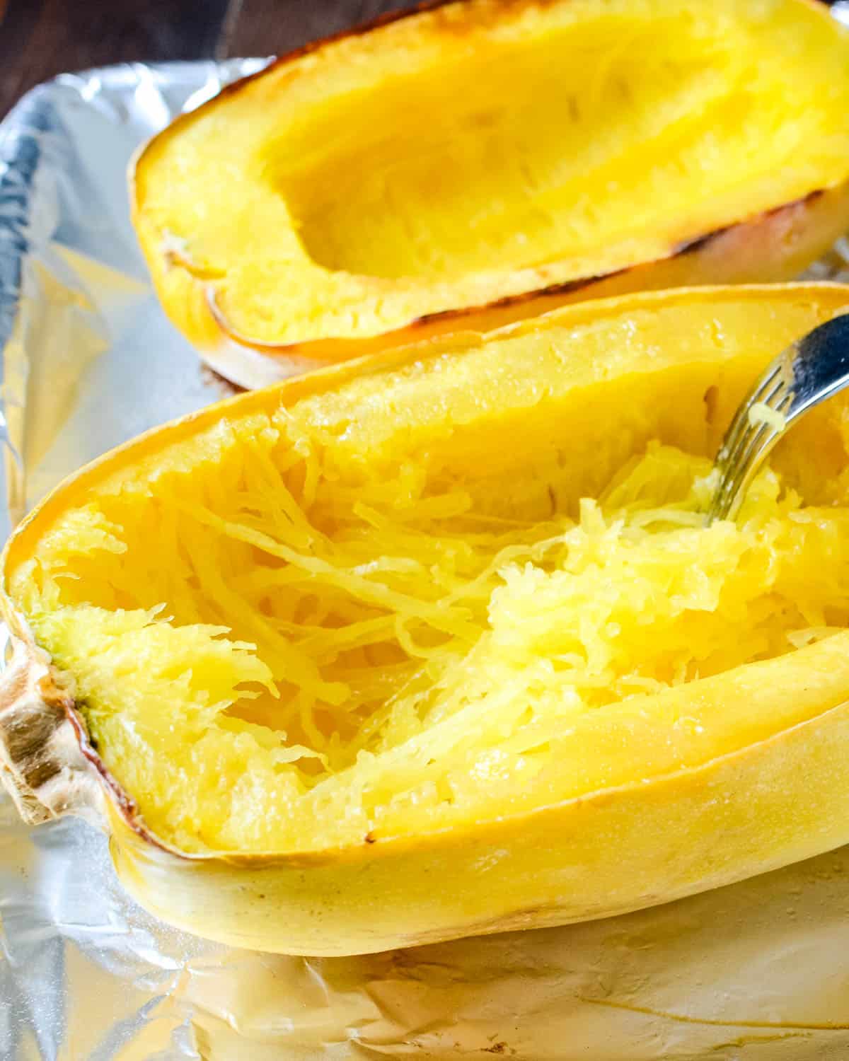 Scraping the strands of spaghetti squash using a fork.