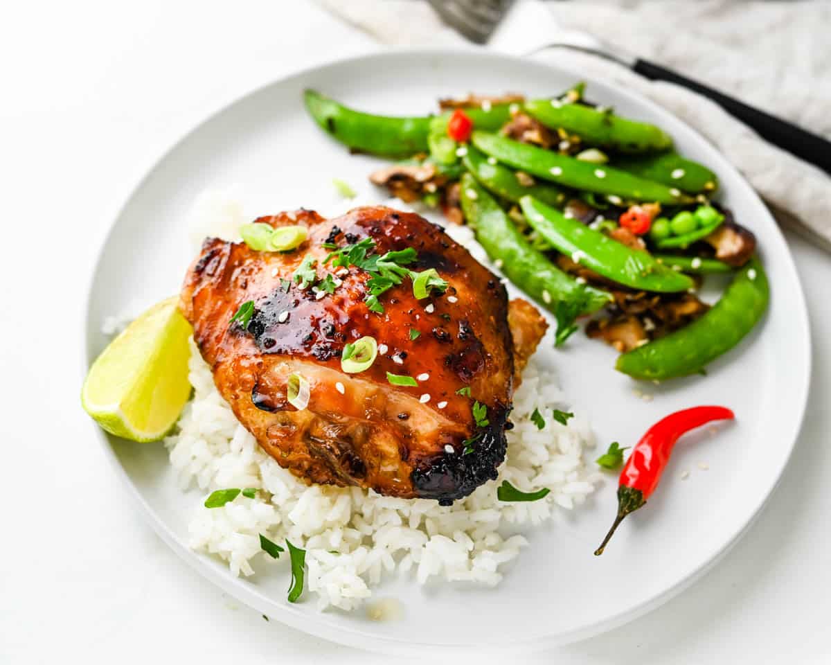 Serve the Asian chicken thighs on a bed of white rice.