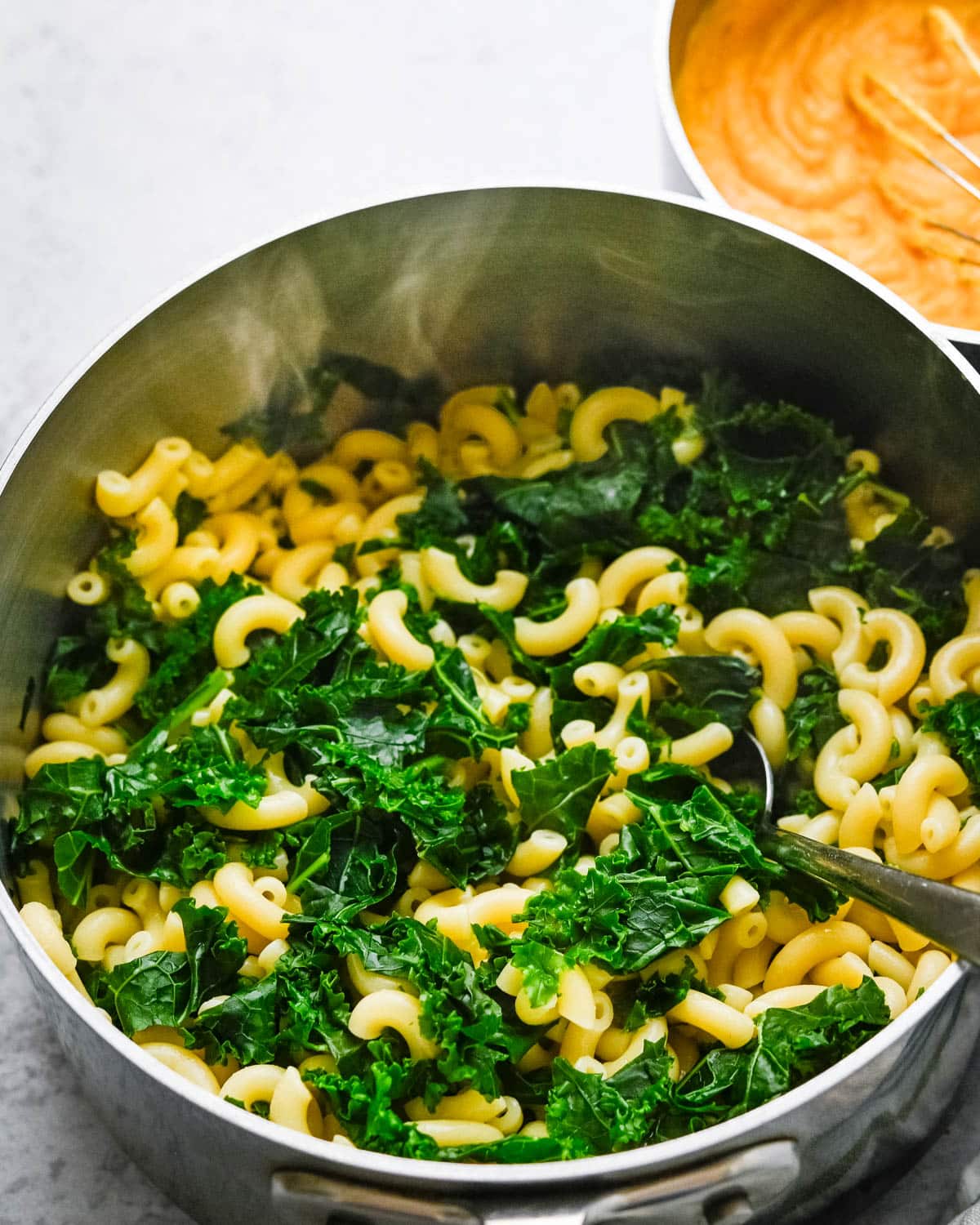 After straining the kale and macaroni, add them back to the pot.