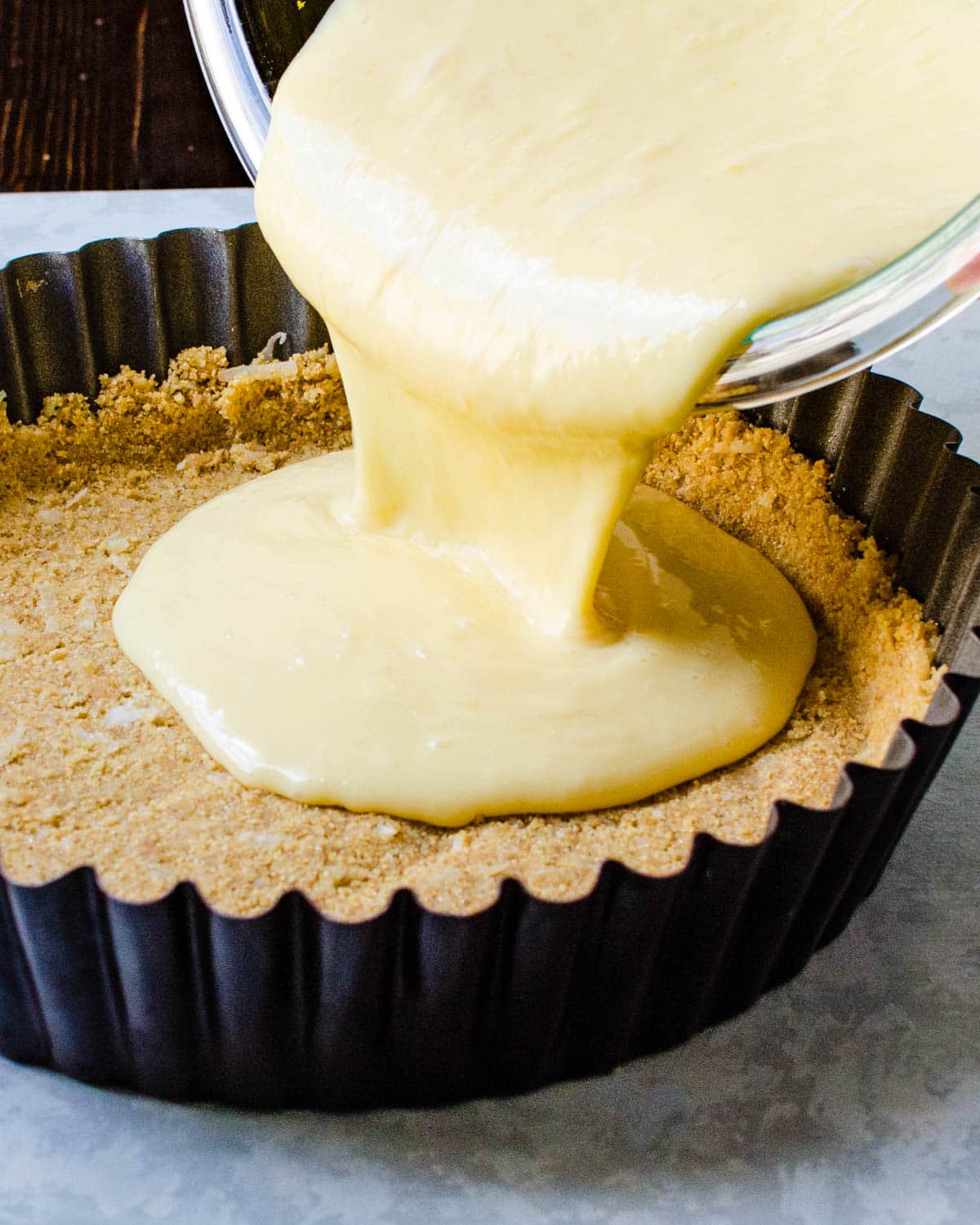 Pouring the pie filling into the prepared graham cracker crust.