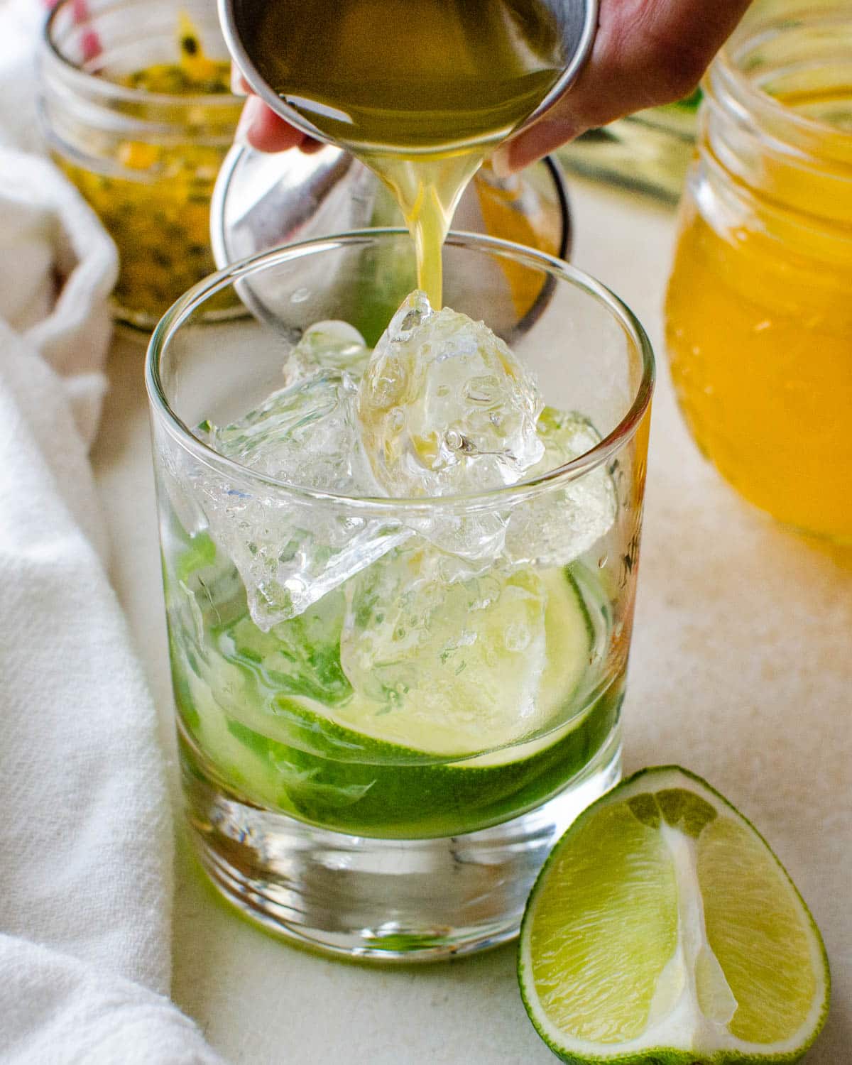 Adding Passion Fruit syrup to the muddled lime and jalapenos.