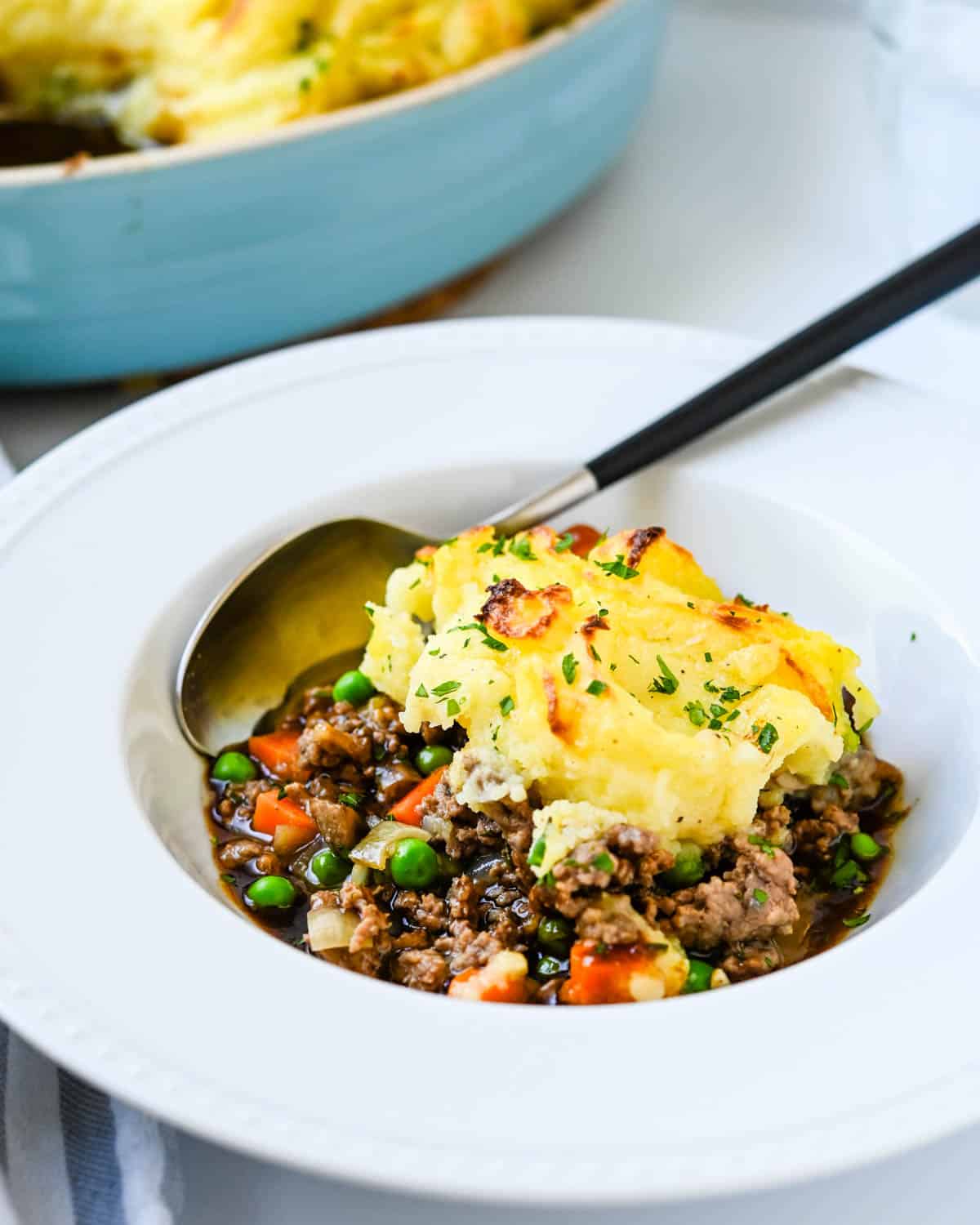 A serving of cottage pie with a spoon.