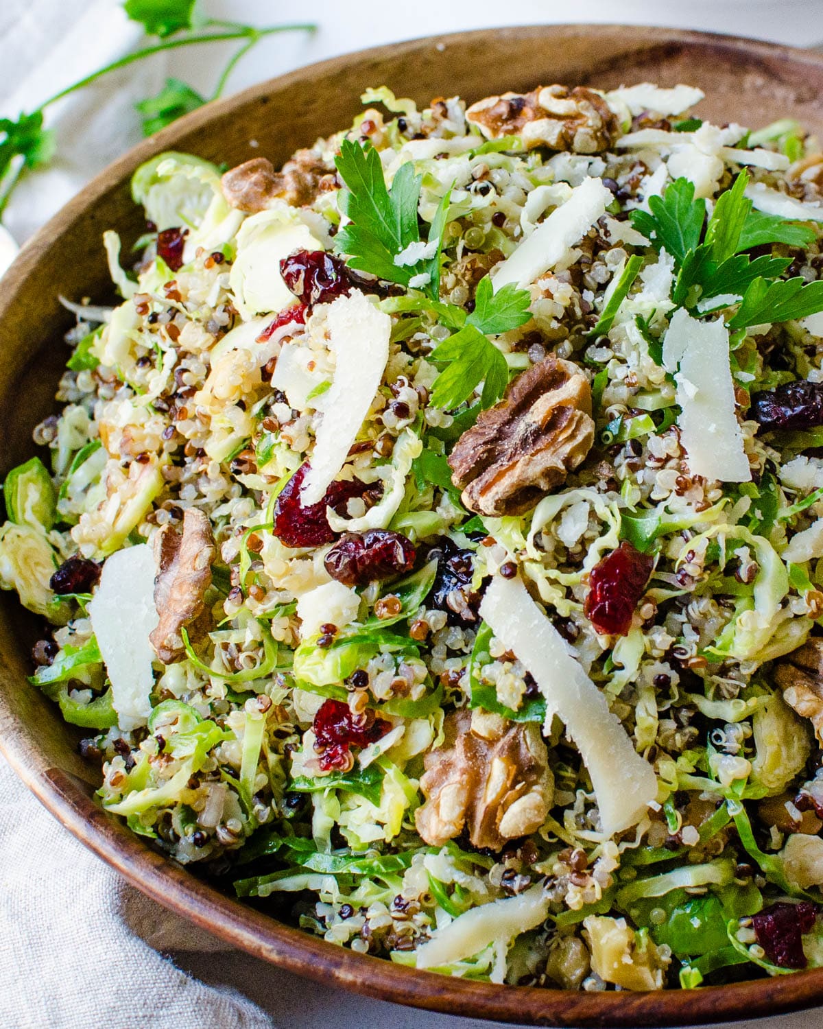 The quinoa brussels sprouts salad in a wooden serving bowl.
