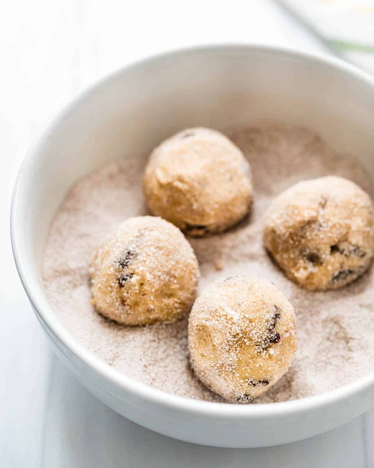 Rolling balls of dough in cardamom spiced sugar.