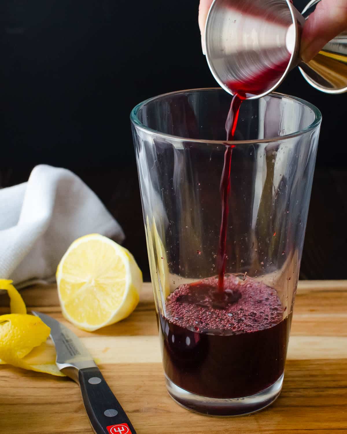 Adding pomegranate juice to the shaker.