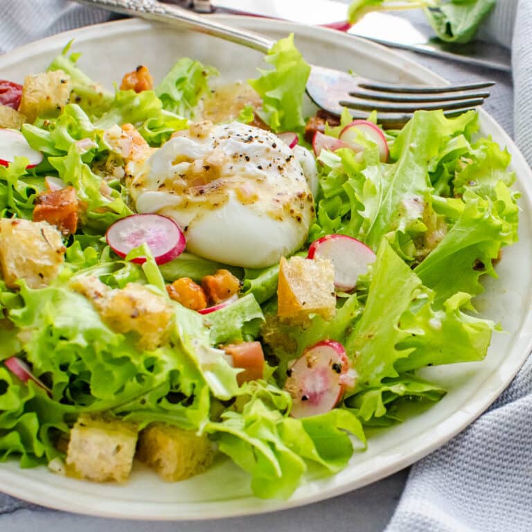 Frisee salad with poached eggs, lardons and croutons.