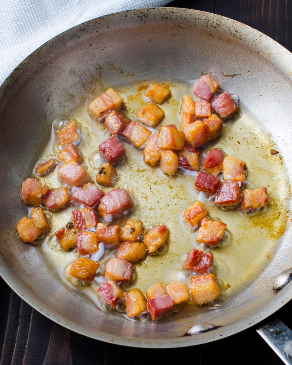 Crisping pancetta in a fry pan.