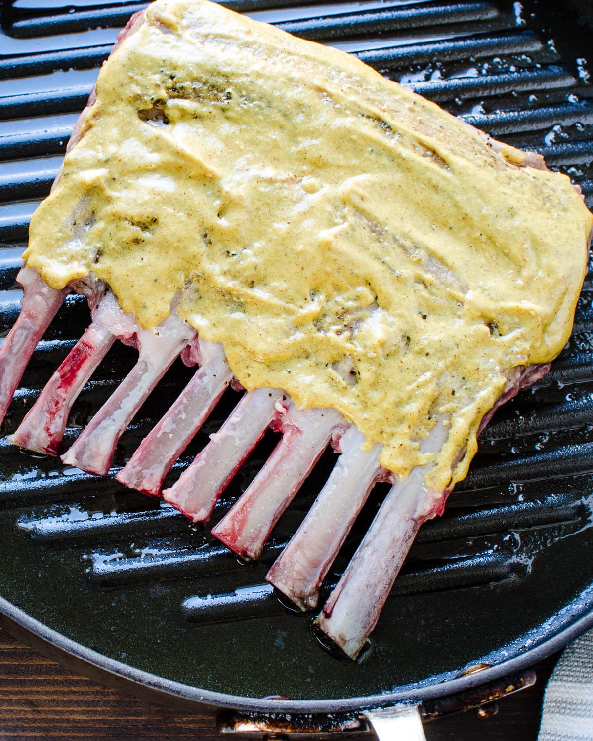 Coat the top of the rack of lamb with mustard.