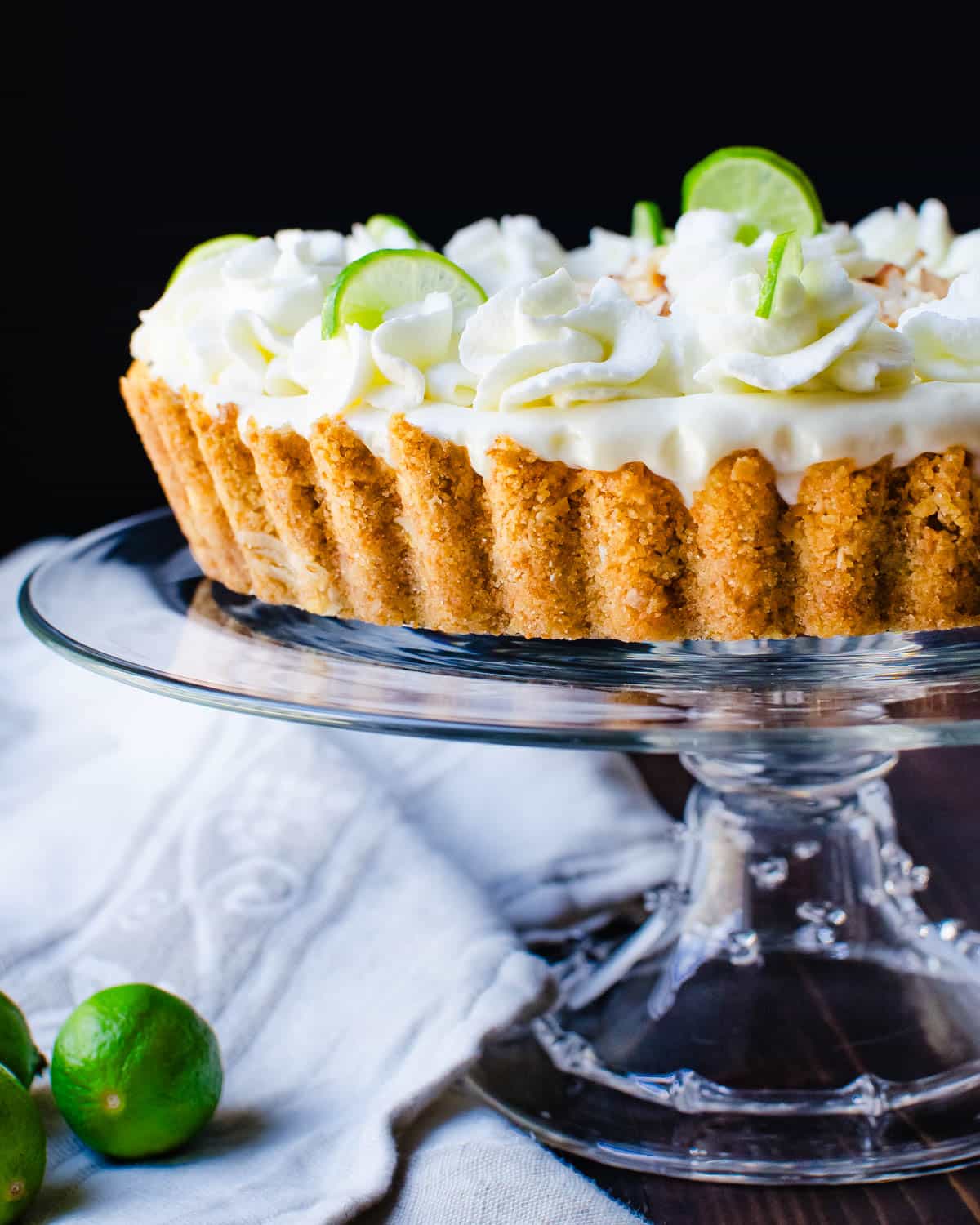 Serving the key lime mousse tart on a cake plate.