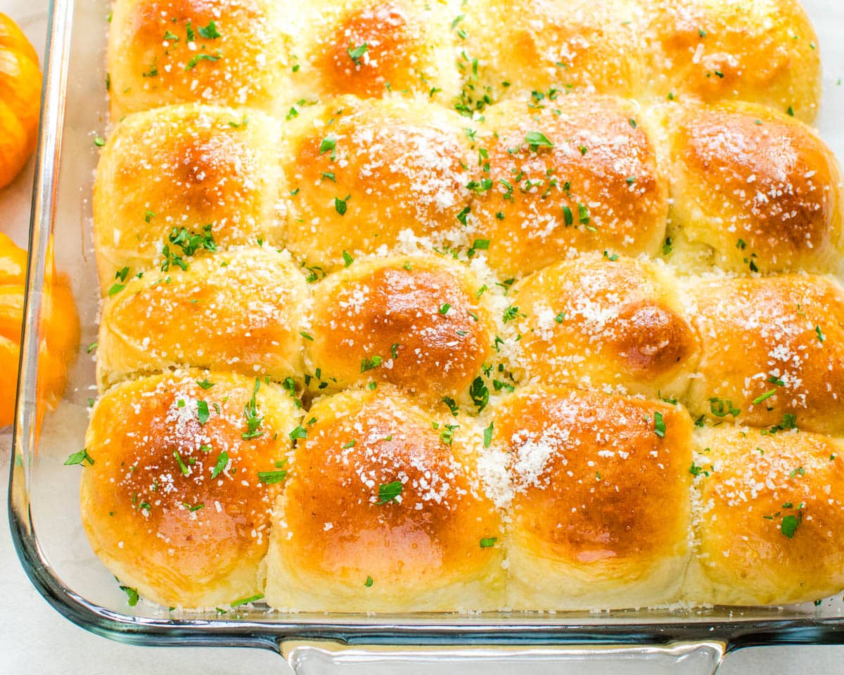 Serving a dish of parmesan yeast rolls.