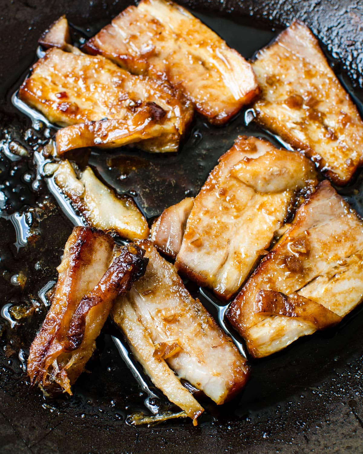 Pan frying the pork belly to release the excess fat.