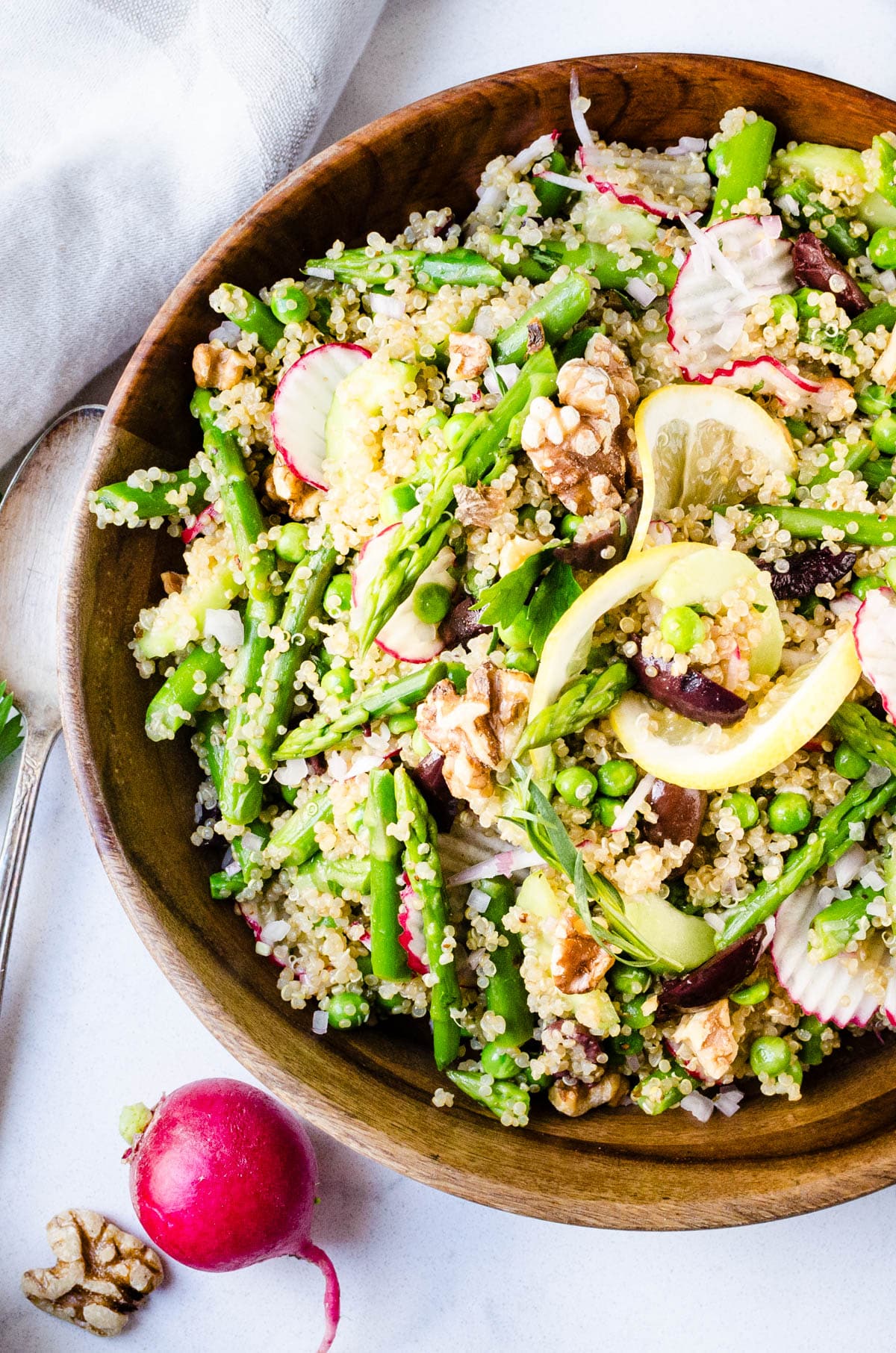 Dressed quinoa salad with asparagus, peas, kalamata olives, radishes and walnuts. 
