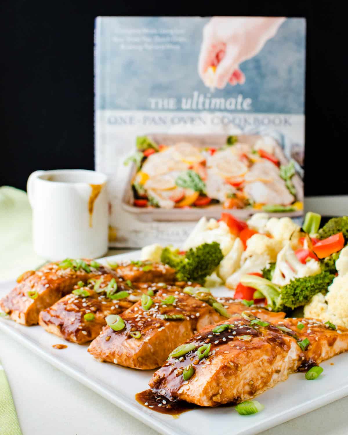The Asian glazed salmon on a platter with a cookbook behind it.