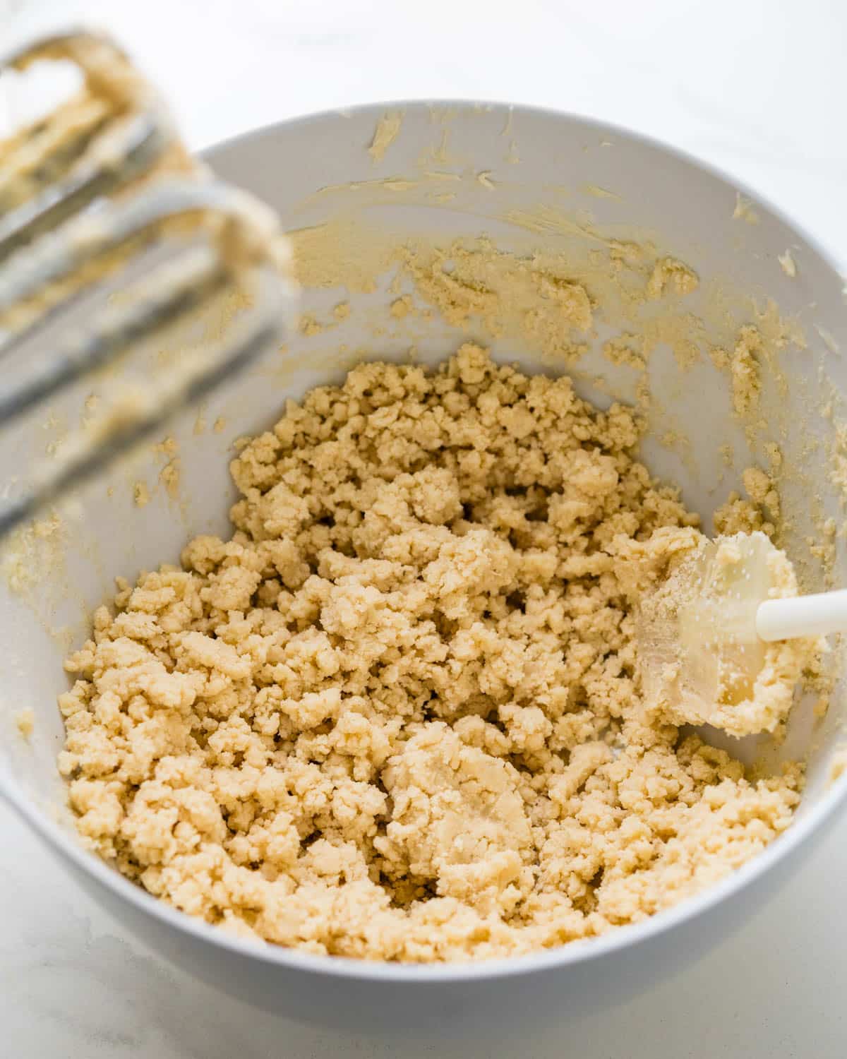 Beating the cookie dough until it's blended.