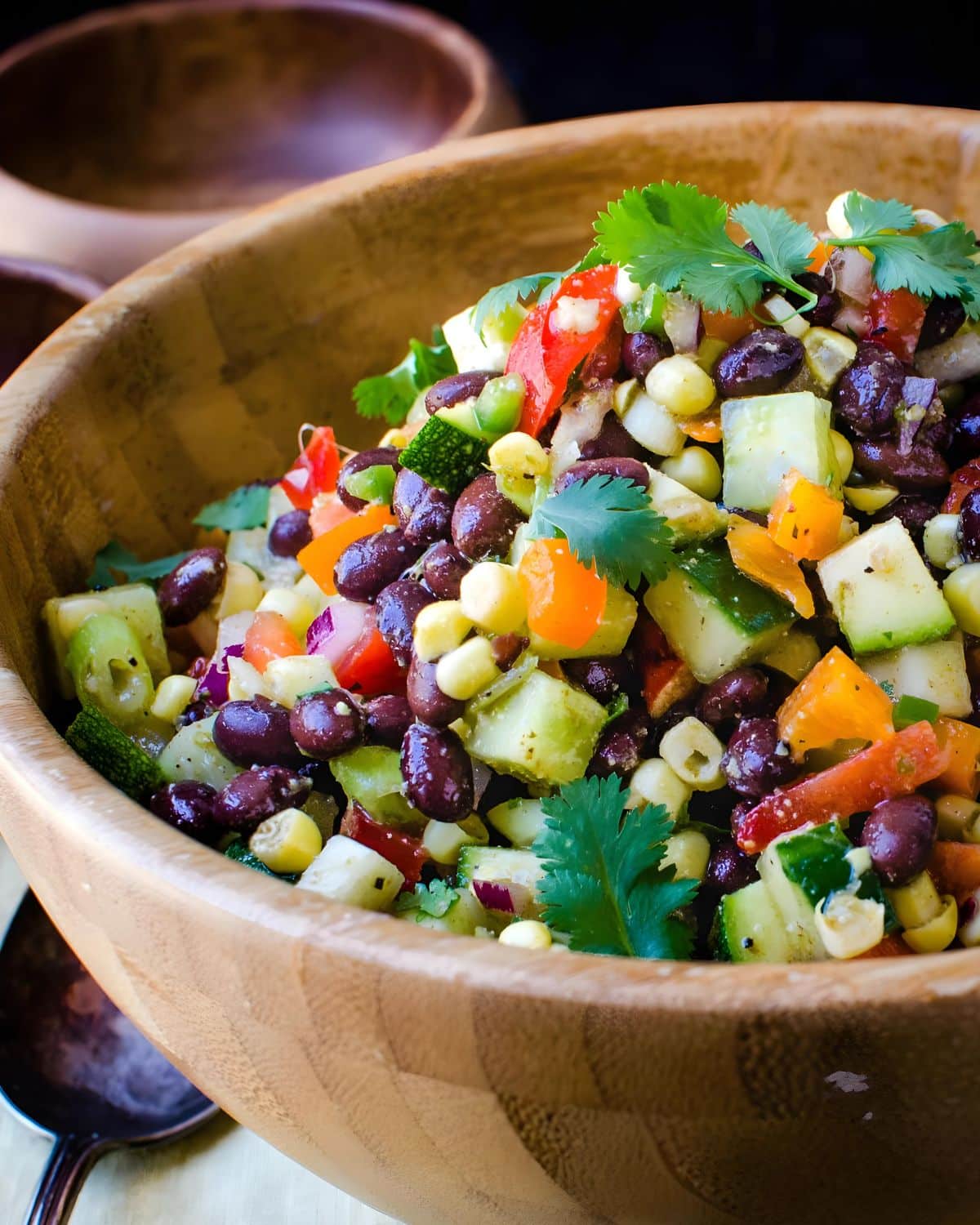 A bowl of Mexican chopped salad with zucchini, cucumbers, peppers and corn.