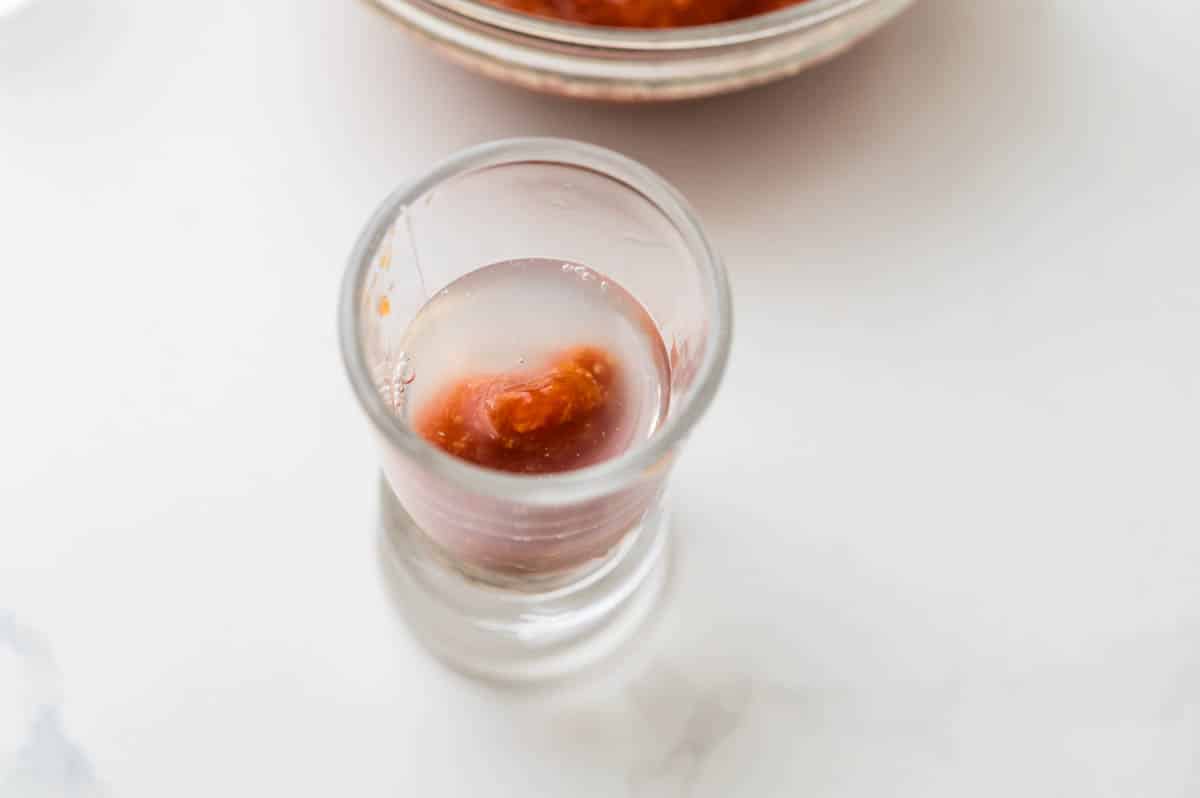 Topping the oyster shooter with vodka.