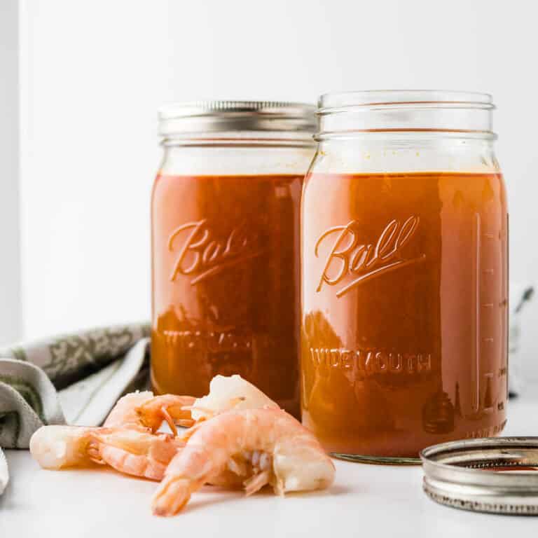 Two quarts of homemade shrimp stock in canning jars.
