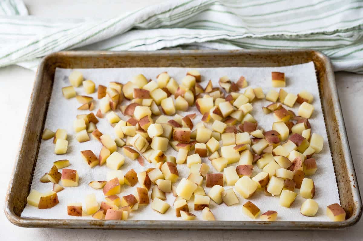 Draining potatoes on a sheet pan lined with paper towels.