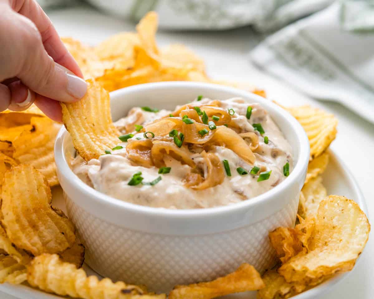 Dipping into the onion and sour cream dip with a potato chip.