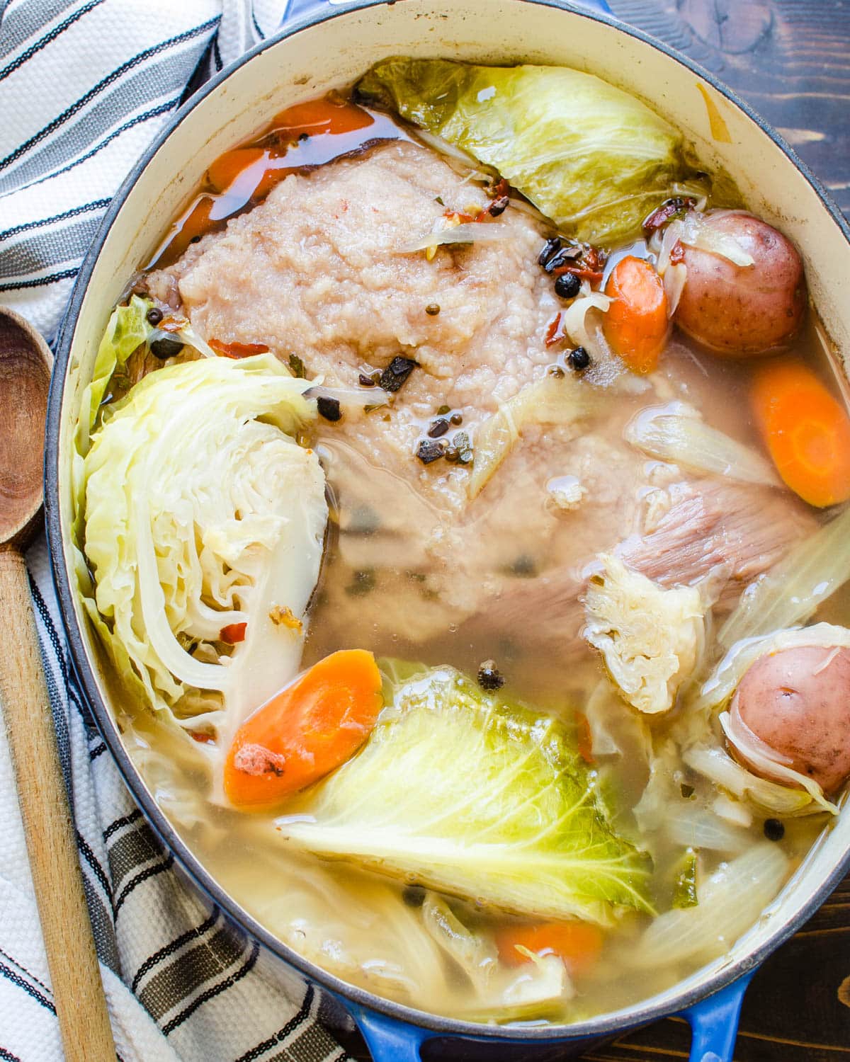 A pot of boiled corned beef with cabbage, potatoes and carrots.