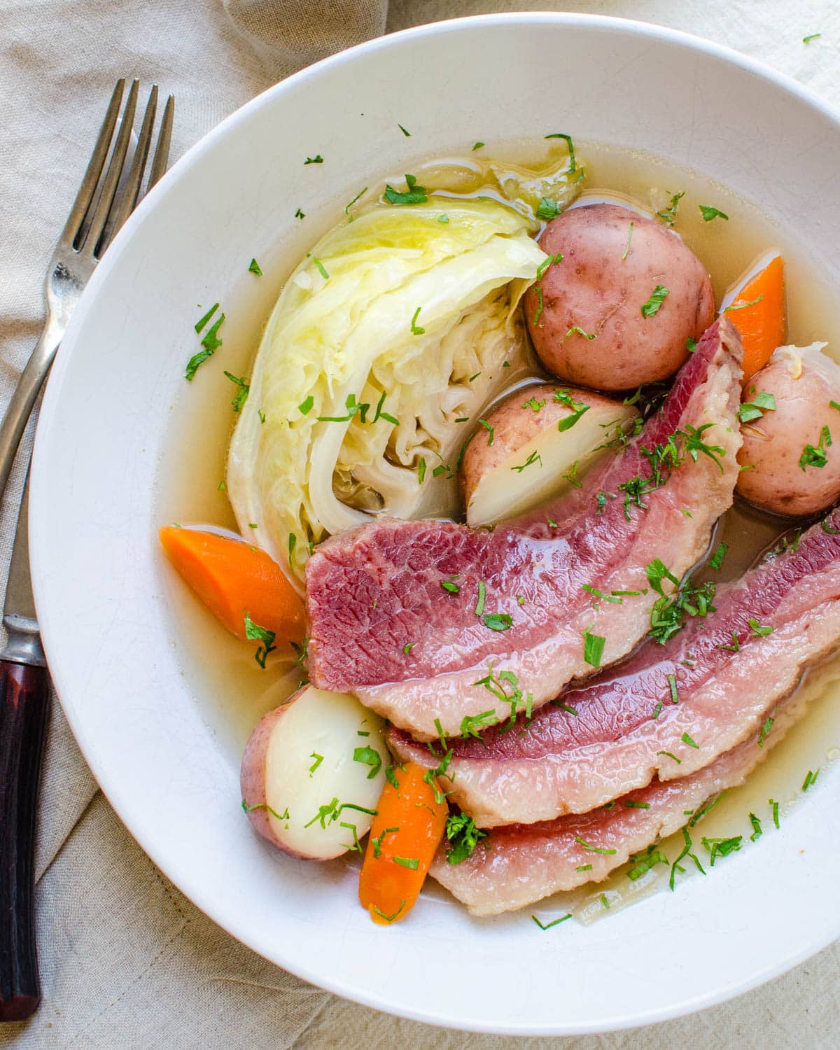 A bowl of corned beef with vegetables.