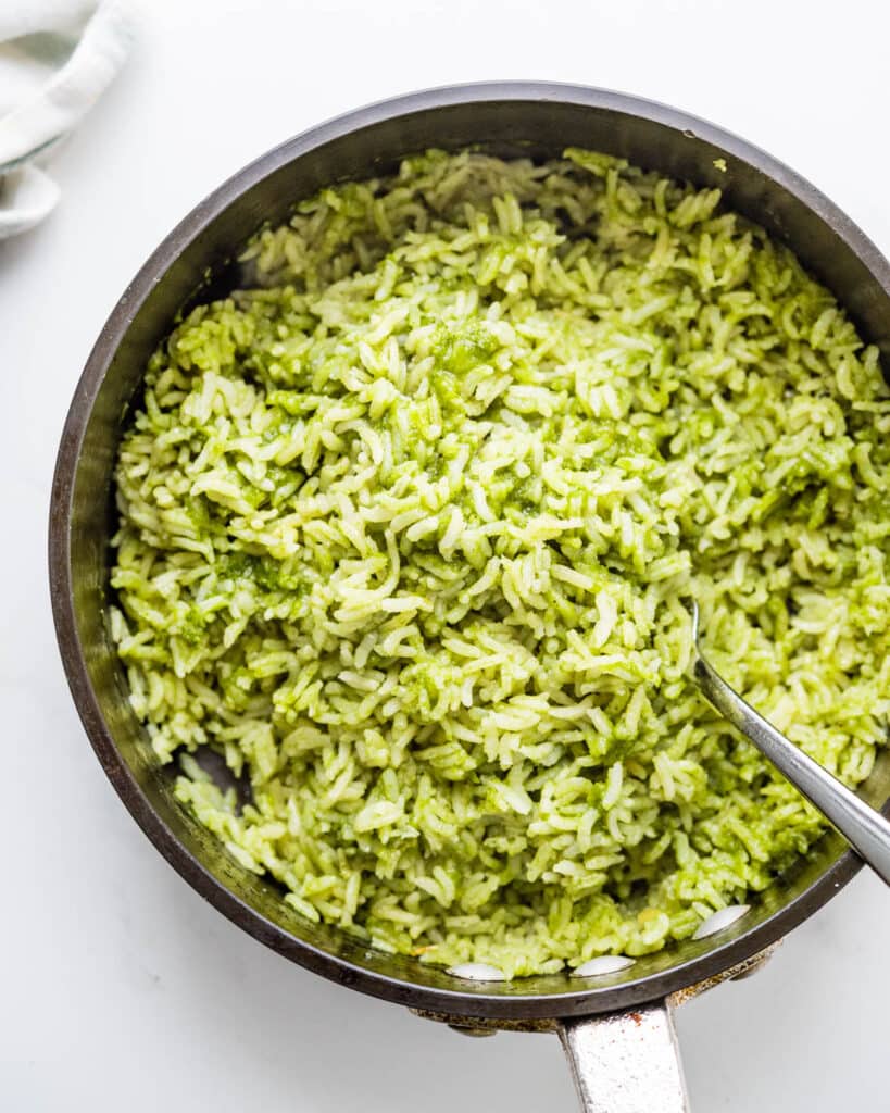 Fluffing the green rice in the pot.